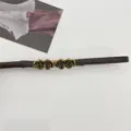 Primer plano de la hebilla de metal de cuatro rosas de bronce vintage y el cinturón fino. - Café