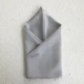 Detailed view of luxury mulberry silk square scarf in elegant light grey with smooth texture. - Gray