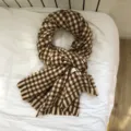 Detailansicht des braun-weißen Hahnentritt-Strickschals mit weicher Textur und Fransen. - Z304-2