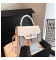 Close-up detail of the stylish spliced shoulder bag featuring a white flap and colorful woven body. - White