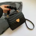 Trendy black quilted crossbody bag with chic scrunchie handle and cute gold heart lock. - Black