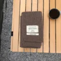 Brauner Strickschal für den Winter mit dekorativem Stoffetikett und gemütlicher Wollstruktur. - Kaffeebraun