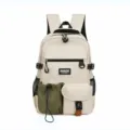 Multi-pocket canvas backpack detail showing front pouch, buckle, and durable black zippers. - Gray