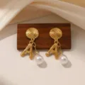 Detailopname van gouden retro oorbellen met spiraalmotief, letter A en parelhanger. - Letter A Kleine Parel (E2260)