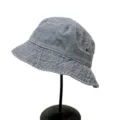 Vue détaillée du bob en denim lavé gris, montrant des coutures fines et des œillets en métal. - Taille unique / Gris clair