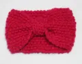 Close-up view of magenta knitted headband with bow detail, warm wool texture for autumn winter. - Red