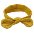 Vista dettagliata della fascia per neonati in maglia gialla con un grazioso fiocco annodato. - Giallo