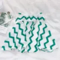 Detailed view of the white and green zigzag patterned clothing item with drawstrings. - Geometric Green