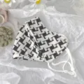 Close up detail of black and white geometric pattern sun protection face mask with adjustable strap. - Geometric