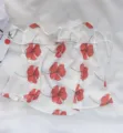 Detailansicht einer weißen Sonnenschutzmaske mit rotem Blumenmuster und praktischen Ohrschlaufen. - Rot