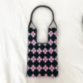 Stricktasche mit Blumenmuster Detail, schwarzes Strickgewebe und rosa Kleeblumen. - Schulterstil / Lila Floral