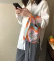 Detailaufnahme einer farbenfrohen Strick-Tasche mit gewebtem Text für Damen und Mode. - Herz Orange