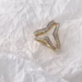 Nahaufnahme eines goldenen Strass-Seidenschalschnalle-Zubehörs auf weisser Papiertextur. - 3-Ring Schalschnalle Gold für Tücher ab 70 cm