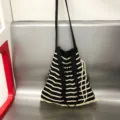 Detail van de gestreepte gebreide schoudertas, casual crossbody shopper voor dames met trekkoord. - Zwart