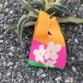 Diese gemütliche Damen Stricktasche mit buntem Blumenmuster ist ideal für den Alltag und Reisen. - Buchstaben-Textur-Stil / Sonnenblumengelb