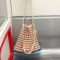 Gedetailleerd uitzicht van de gebreide gestreepte schoudertas met geplooide textuur. - Rood + Blauw