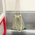 Detail van gebreide gestreepte schoudertas, casual ontwerp met koord sluiting. - Donkergroen