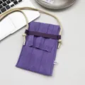 Detailansicht der violetten Mini-Knitted-Handytasche mit weicher Textur und Schulterriemen. - Lila