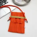 Mini Strick Umhängetasche für Handys in leuchtendem Orange mit schicken Plissees. - Orange