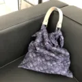 Detailansicht einer stilvollen Paisley-Stofftasche mit Ledergriff und elegantem Knotendesign. - Dunkelblau