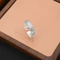 Primo piano dettagliato di un elegante anello aperto in argento con pietre di zircone scintillanti. - Stile Strass Traforato (JZ0063)