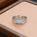 Close-up of niche silver irregular metal ring with white stone on tray, elegant detail shot. - Lava Cat's Eye Style (JZ0220)