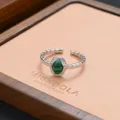 Detailed shot of an open silver ring with a green malachite stone on a jewelry tray. - Vintage Oval Malachite Style (JZ0277)