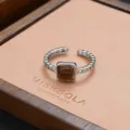 Detailed shot of a stylish silver open ring with a square brown stone on a display pad. - Bumpy Texture Brown Stone Style (JZ0278)