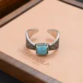 Vintage synthetic turquoise ring with retro carved details on wooden display tray. - Antique Carved Square Turquoise Style (JZ0282)