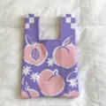 Purple knitted tote bag with cute pink peach and white flower pattern for daily use. - Handheld Style / Purple