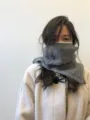 Primer plano detallado de un calentador de cuello de punto gris, accesorio de invierno. - Gris claro