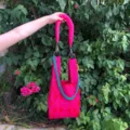 Vue détaillée du sac porté épaule en tricot rose avec motif géométrique et chaîne épaisse. - Style Bandoulière Originale / Rose rouge