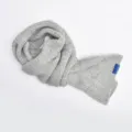 Detailed shot of the soft grey knit cross scarf, showcasing the cozy texture and weave. - Light Gray