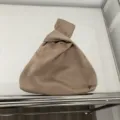 Detaillierte Nahaufnahme einer eleganten Satintasche mit Knoten in Taupe Farbe minimalistisch - Khaki