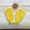 Detalle en primer plano de guantes de invierno de punto amarillo con etiqueta de cuero. - 24x12cm-S406C / Amarillo