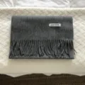 Detalle bufanda invierno de lana gris, textura de flecos acogedora y material suave. - Gris