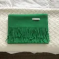 Primer plano de una bufanda de invierno de lana verde brillante con flecos detallados. - Verde esmeralda
