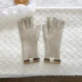 Close-up detail of warm knitted winter gloves featuring stylish ribbed cuffs and chic woven labels. - Touch Screen Knitted Gloves / Khaki