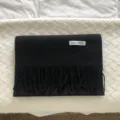 Primer plano de la textura de la bufanda de lana negra con flecos y detalle, accesorio. - Negro