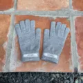 Nahaufnahme von grauen Strick-Winterhandschuhen mit Bündchen-Etikett, warmer Wollstoff. - 21x11cm-H005S / Hellgrau