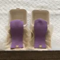 Dettaglio ravvicinato di guanti invernali lavorati a maglia viola esposti nelle scatole. - Viola / 23x9cm