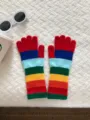 Detailed view of colorful striped knitted gloves with touchscreen fingertips and cozy winter design. - 28X12CM-E104S / Red