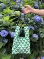 Vista dettagliata di borsa tote in maglia geometrica verde e bianca con manici in giardino. - Stile Tracolla in Pelle PU / Verde
