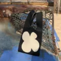Detailaufnahme einer schwarzen Stricktasche mit beigem Blumenmuster, lässiger Outdoor-Stil. - Handtasche Stil / Schwarz