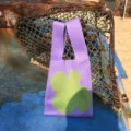 Gestrickte Blumentasche Detailaufnahme, mit stylischem lilafarbenem und grünem Blumenmuster. - Handtasche Stil / Lila