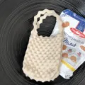 Mini gebreide handtas in beige met golvend handvat, chic modeaccessoire voor dagelijks. - Ivoor