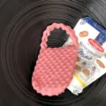 Close-up detail van een roze gebreide mini handtas met uniek textuur patroon en gegolfde handvat. - Roze