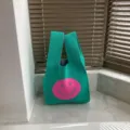 Grüne Strick-Tragetasche mit einem süßen rosa Smiley-Gesicht für den täglichen Gebrauch. - Seeblau