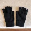 Nahaufnahme von schwarzen Strickhandschuhen mit süßen Schleifen. Weich und warm für den Winter. - 21x11cm-U203S / Schwarz