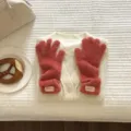 Close-up detail shot of winter plush five-finger gloves in cozy pink display setting. - 27X10CM-W207MD / Brick Red